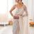 Cream chiffon embellished saree with unstitched blouse piece.