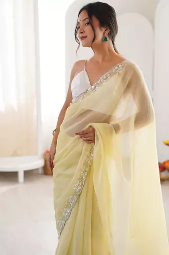 Yellow chiffon embellished saree with unstitched blouse piece.