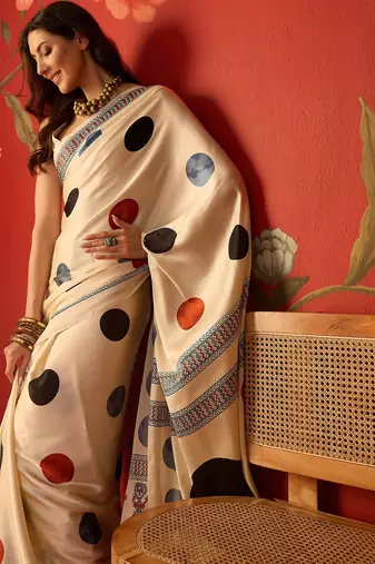 Cream satin printed saree with unstitched blouse piece.