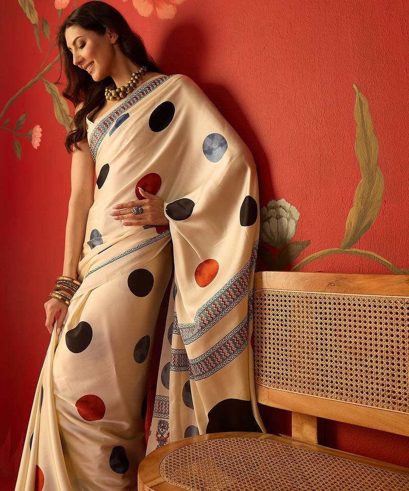 Cream satin printed saree with unstitched blouse piece.