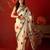 Cream satin printed saree with unstitched blouse piece.