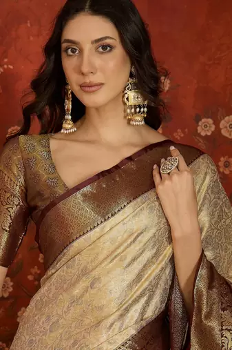 cream kanjeevaram silk blend woven design saree with unstitched blouse piece.