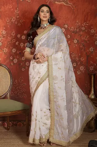 Cream tissue satin embroidered sequin saree with unstitched blouse piece.