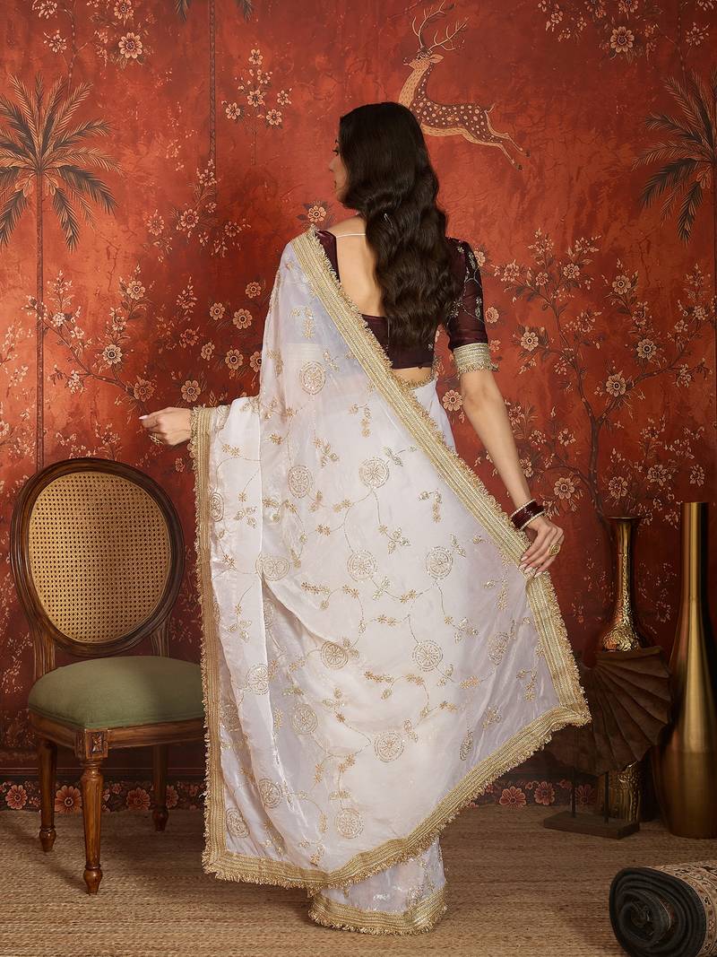 Cream tissue satin embroidered sequin saree with unstitched blouse piece.