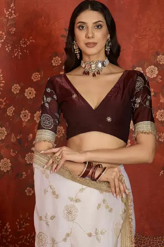 Cream tissue satin embroidered sequin saree with unstitched blouse piece.