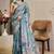 Turquoise shimmer printed zari saree with unstitched blouse piece.