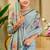 Sky blue shimmer printed zari saree with unstitched blouse piece.