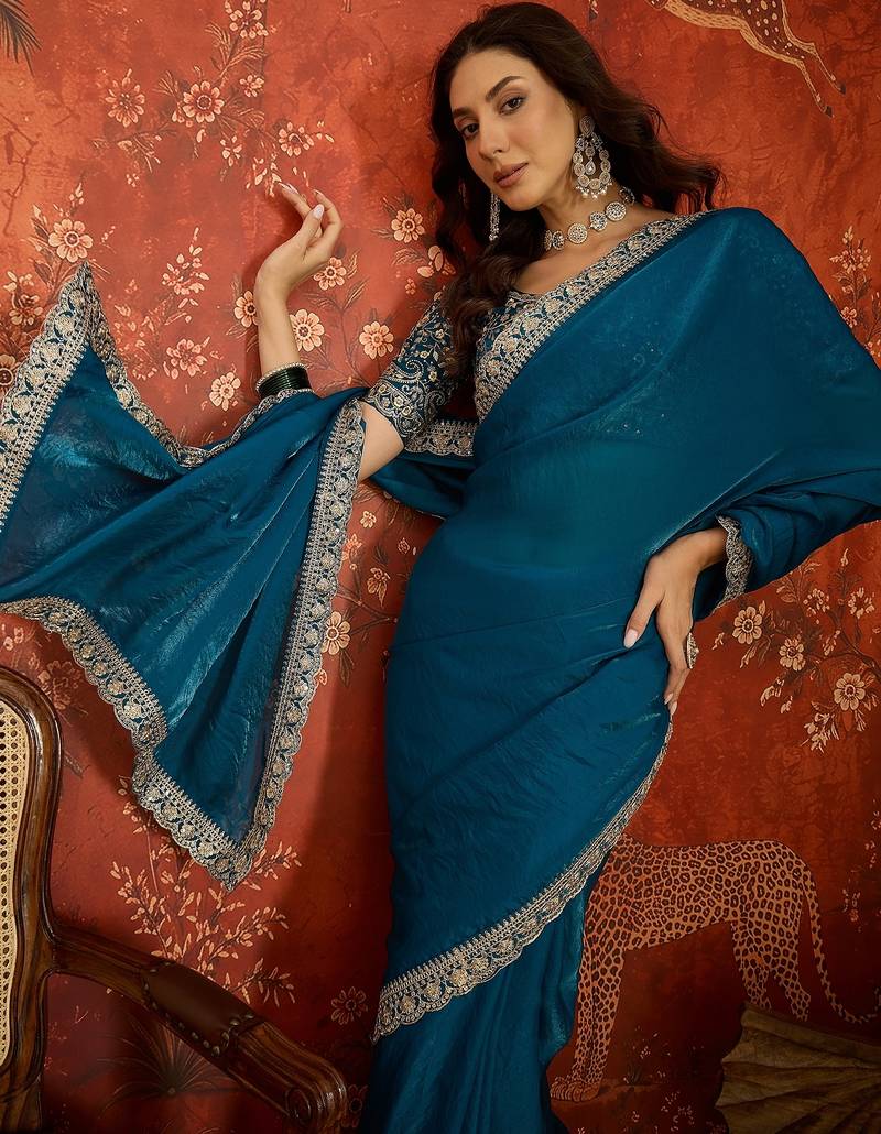 Teal tissue satin embroidered saree with unstitched blouse piece.