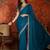 Teal tissue satin embroidered saree with unstitched blouse piece.