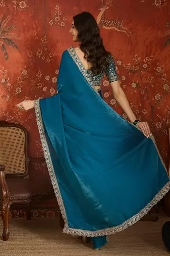 Teal tissue satin embroidered saree with unstitched blouse piece.