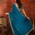 Teal tissue satin embroidered saree with unstitched blouse piece.