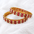 Gold-toned pearl bangle set with ruby & emerald stones