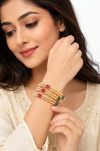 Gold-toned pearl bangle set with ruby & emerald stones set of 4 bangles, traditional design, festive wear.