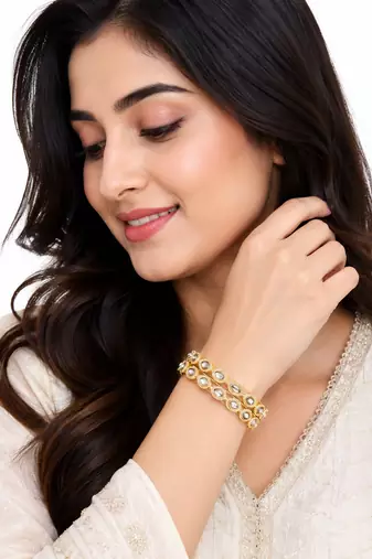 Gold-toned kundan bangles with teardrop stones, set of 2 filigree design, ethnic wear, white stone embellished.