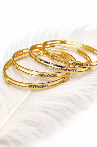 Gold-plated bangle set with crystal embellishments, set of 4 diamond-cut accents, women's jewellery, stackable design.