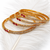 Gold-plated bangles set of 4 with ruby & white stones traditional design, teardrop ruby accent, crystal embellished.