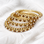Gold-toned pearl and crystal studded bangles set amber crystal stones, faux pearl accents