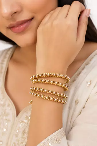 Gold-toned pearl and crystal studded bangles set amber crystal stones, faux pearl accents