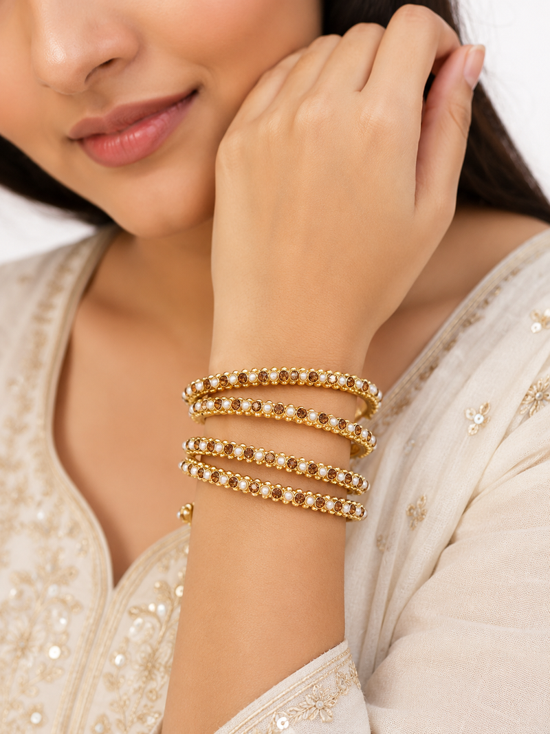 Gold-toned pearl and crystal studded bangles set amber crystal stones, faux pearl accents