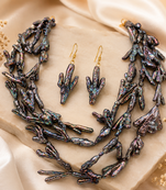 Baroque pearl necklace and earring set, dark iridescent multi-strand necklace, cactus-shaped earrings.