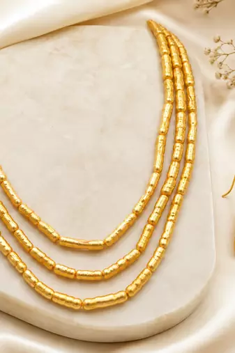 Gold-toned 3-layer beaded necklace and earrings jewellery set cylindrical beads.