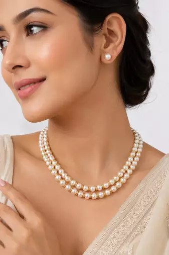 Double strand pearl necklace set with gold rondelle spacers includes stud earrings, layered design.