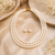 3-layer pearl necklace and earring set, white stud earrings included, gold-tone clasp, layered design.