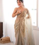 Beige tissue satin sequins saree with unstitched blouse piece.