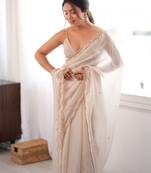 Cream tissue satin sequins saree with unstitched blouse piece.