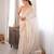 Cream tissue satin sequins saree with unstitched blouse piece.