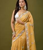 Mustard tissue satin embellished saree with unstitched blouse piece.