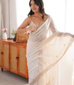Cream tissue satin embroidered saree with unstitched blouse piece.