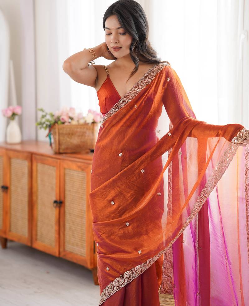 Orange tissue satin embroidered saree with unstitched blouse piece.