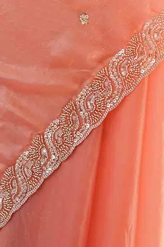 Peach tissue satin embroidered saree with unstitched blouse piece.