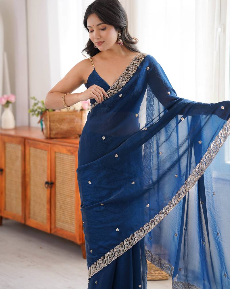 Teal tissue satin embroidered saree with unstitched blouse piece.
