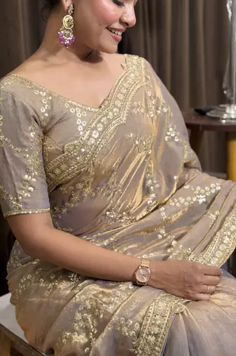 Beige tissue satin embroidered saree with unstitched blouse piece.