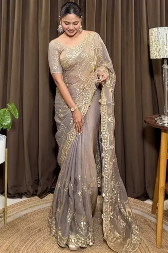 Beige tissue satin embroidered saree with unstitched blouse piece.