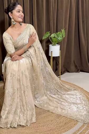 Cream tissue satin embroidered saree with unstitched blouse piece.