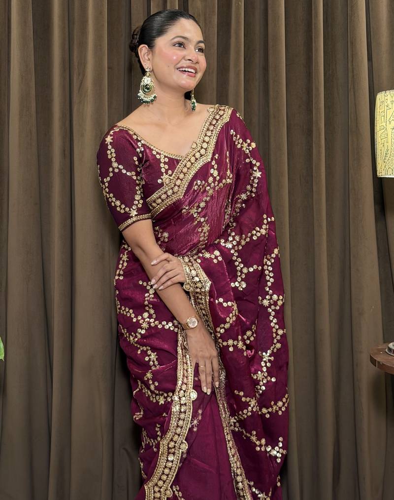 Wine tissue satin embroidered saree with unstitched blouse piece.