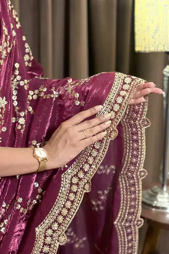 Wine tissue satin embroidered saree with unstitched blouse piece.