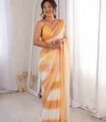 Mustard tissue satin striped saree with unstitched blouse piece.
