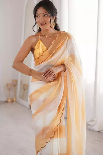 Mustard tissue satin striped saree with unstitched blouse piece.