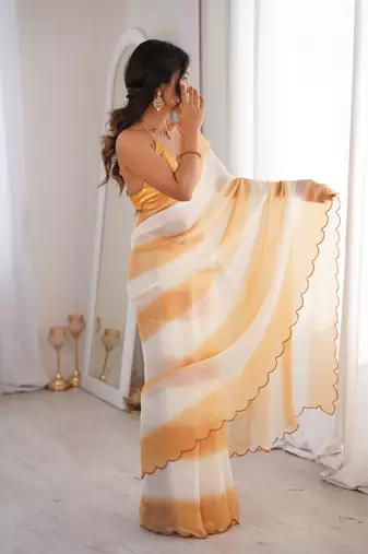 Mustard tissue satin striped saree with unstitched blouse piece.