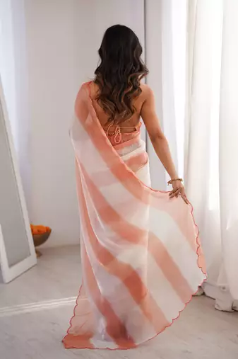 Peach tissue satin striped saree with unstitched blouse piece.