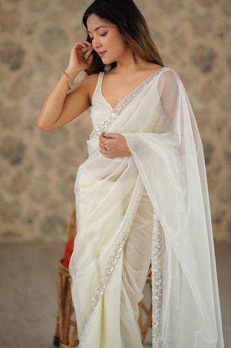 Cream net embellished saree with unstitched blouse piece.