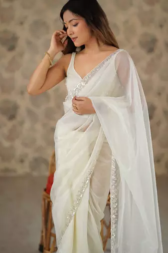 Cream net embellished saree with unstitched blouse piece.