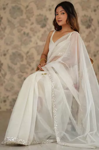 Cream net embellished saree with unstitched blouse piece.