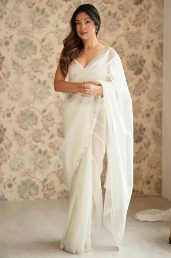 Cream net embellished saree with unstitched blouse piece.