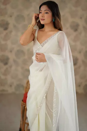 Cream net embellished saree with unstitched blouse piece.