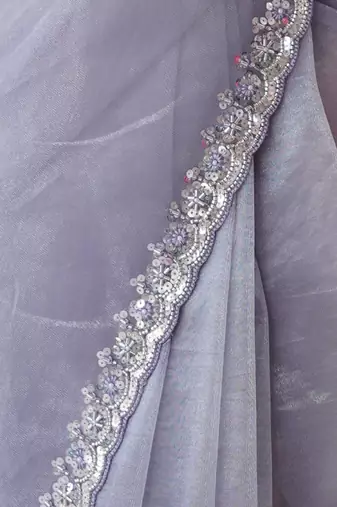 Lilac net embellished saree with unstitched blouse piece.